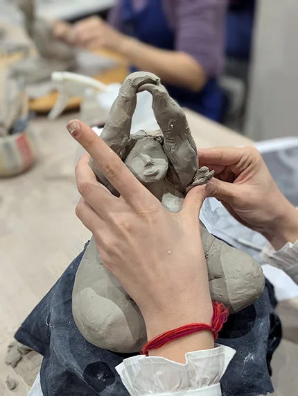 Modelage d'une danseuse pendant un cours de céramique